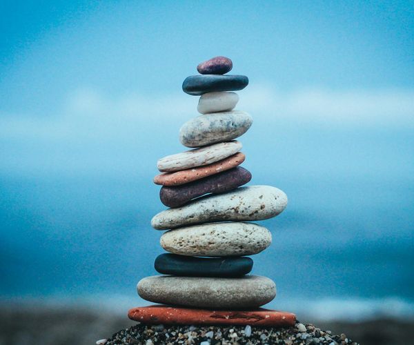 A balanced stack of stones on a serene beach.