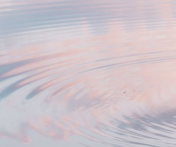 Calm water surface reflecting the sky, representing mental peace.